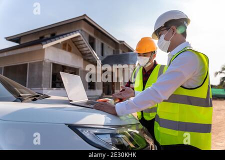Architect and Supervisors using laptop at construction site, House construction ideas during the coronavirus outbreak. House builder concept. Stock Photo