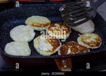 Fry cheese cakes at home in a pan Stock Photo