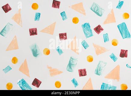Multicolored circles and squares stamped amidst triangles and rectangles on white paper sheet Stock Photo