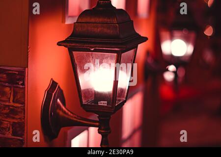 Street lamp lit up at night on the wall of an old colonial building in San Telmo, Buenos Aires, Argentina Stock Photo