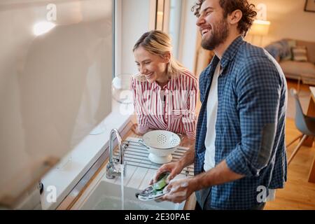 Lovely couple doing the dishes together in the kitchen Stock Photo