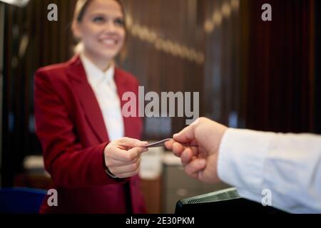 A lovely female receptionist behind the counter working at the hotel. Tourism, business, hotel Stock Photo