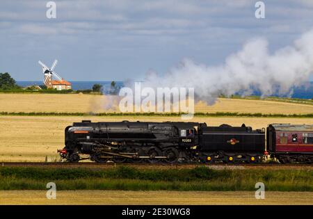 BR Standard Class 9F Black Prince 92203  passing Weybourne windmill, North Norfolk Railway Stock Photo