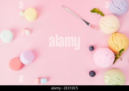 Top view of various flavored delicious ice cream scoops, macaroons and berries Stock Photo
