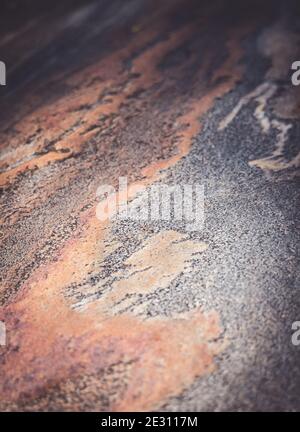 The orange and grey seams within granite rock polished by flowing water Stock Photo