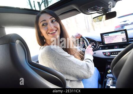 Munich, Deutschland. 15th Jan, 2021. Themed picture woman at the wheel of a car. A young woman sits at the wheel of a passenger car and looks backwards. MODEL RELEASED! | usage worldwide Credit: dpa/Alamy Live News Stock Photo