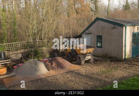 Construction Site with a Dumper Truck and Piles of Sand and Gravel to Convert an Outdoor Building in Rural Devon, England, UK Stock Photo