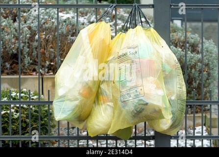 Kleinmachnow, Germany. 14th Jan, 2021. Four yellow garbage bags hang outside on a garden fence ready for pickup. Credit: Soeren Stache/dpa-Zentralbild/ZB/dpa/Alamy Live News Stock Photo