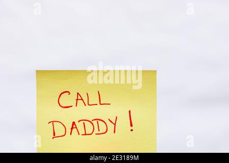 Call daddy handwriting text close up isolated on yellow paper with copy space. Stock Photo