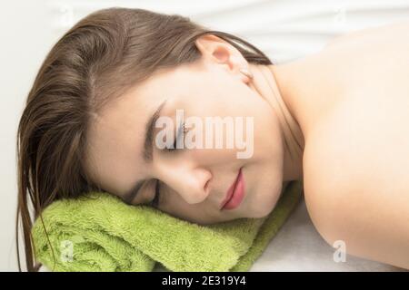 Young woman resting in a massage parlor, put her head on towel. Stock Photo