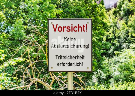 German warning sign with the inscription Vorsicht, keine Absturzsicherung! Trittsicherheit erforderlich! Stock Photo