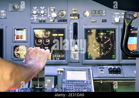 Captain hand accelerating on the throttle in commercial airliner flight simulator - Cockpit thrust levers on the phase of takeoff Stock Photo