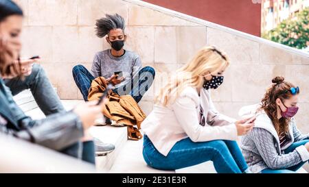 Urban millennial people using smart phones with face mask on Covid second wave - Serious guy watching news on mobile smartphone Stock Photo