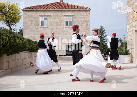 Konavle, Croatia, Oktober 5th 2019. Men and woman wearing traditional Croatian folklore costumes while dancing and performing a show in a rural area w Stock Photo