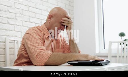Image with an Upset and Disappointed Businessman Using a Laptop Stock Photo