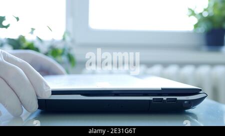 Closeup Image with Hands Wearing Protective Gloves Using the Laptop Keypad Stock Photo