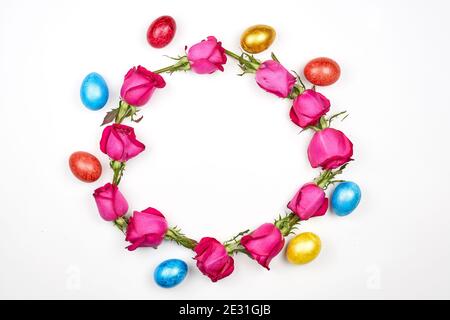 Colorful Easter eggs and rose flowers in form of a circle on white background Stock Photo