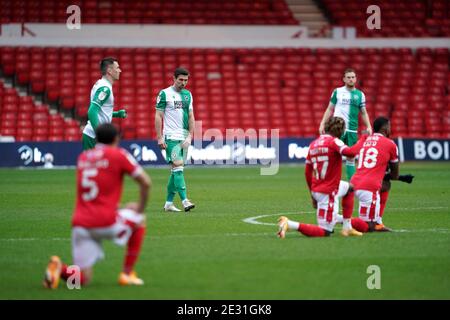 Millwall players stand whilst Nottingham Forest players take a knee before the Sky Bet Championship match at the City Ground, Nottingham. Stock Photo