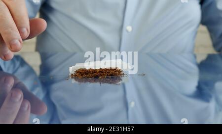 Handmade Cigarette Using Cigarette Paper, Filter, and Tobacco Stock Photo