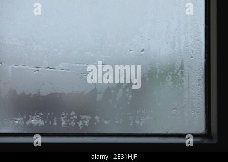 Water drops on the glass, abstract pattern. Steam condensation on the window, winter. Stock Photo