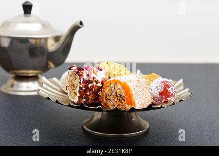 Asorti of oriental sweets in a low metal vase on a dark table. Shallow focus. Stock Photo