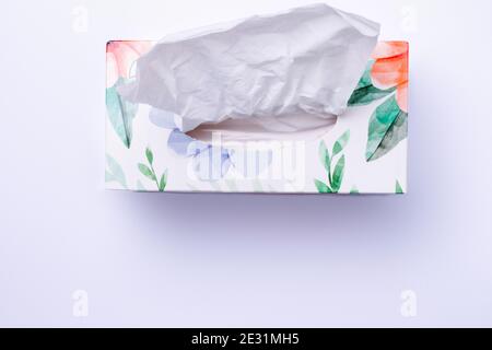 Colored box with disposable paper napkins on white background with bottom blank space. Stock Photo