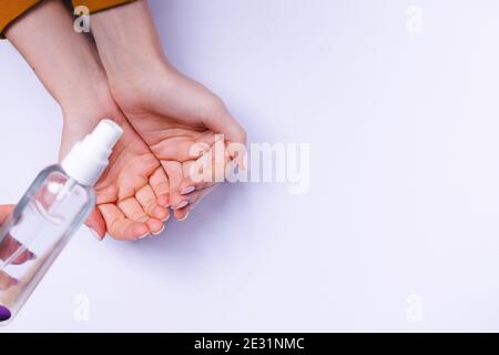 Hand protection against bacteria. Female hands and antiseptic spray on a white background. Stock Photo