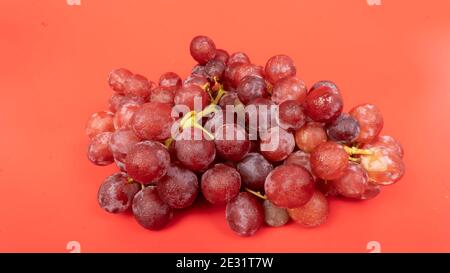 Fresh red grapes isolated on pink background. Selective focus on the fresh red grapes. Stock Photo