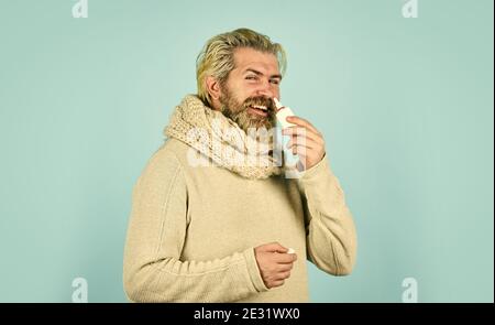 man treat runny nose with nasal spray. free your stuffy nose. no addiction to medicals. coronavirus from china. happy hipster presenting best remedy. Nasal drops plastic bottle. pandemic concept. Stock Photo