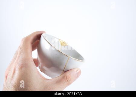 Gray Kintsugi bowl, real gold restoration, japanese technique Stock Photo