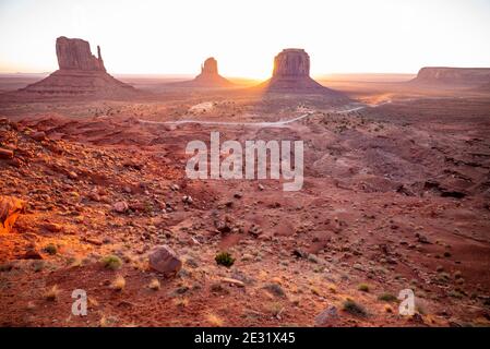 The famous West Mitten, East Mitten and Merrick Butte rock formations backlit at sunrise in Monument Valley Navajo Tribal Park, Arizona and Utah, USA Stock Photo