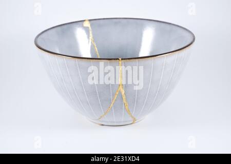 Gray Kintsugi bowl, real gold restoration, japanese technique Stock Photo