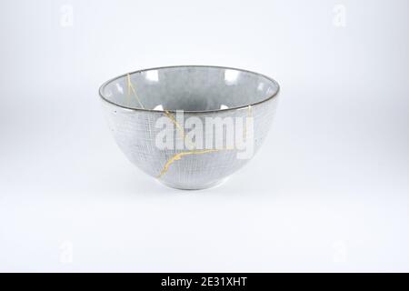 Gray Kintsugi bowl, real gold restoration, japanese technique Stock Photo