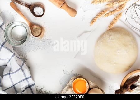 Dough and ingredients for the preparation of pasta, dough, eggs, flour, water and salt on a light rustic old table. Top view. Stock Photo