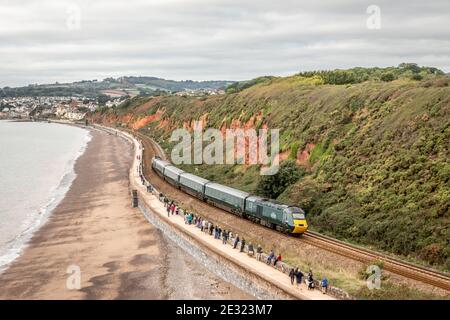 First Great Western Class 43 No. 43198 as part of a  and a 'Castle Class' set skirts along the sea wall at pass Dawlish, Devon Stock Photo