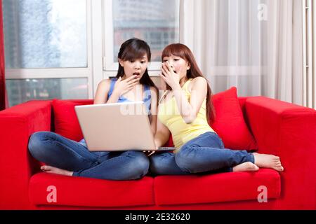 Portrait of two female friends using laptop high quality photo Stock Photo