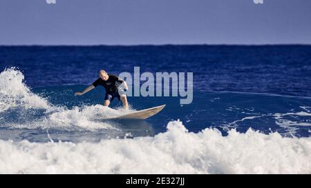 A man learns to stand on a surfboard. Surf school. Water sports, Atlantic ocean Dominican Republic. 29.12.2016. Stock Photo