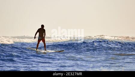 A man learns to stand on a surfboard. Surf school. Water sports, Atlantic ocean Dominican Republic. 29.12.2016. Stock Photo