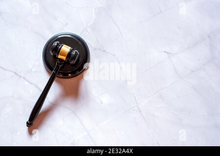 Judge's hammer on a white marble background