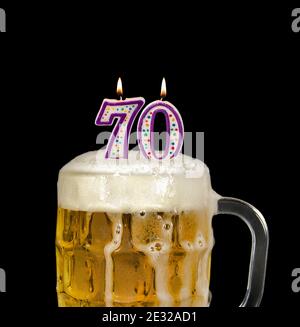 number 70 candles in beer mug for birthday celebration isolated on black Stock Photo