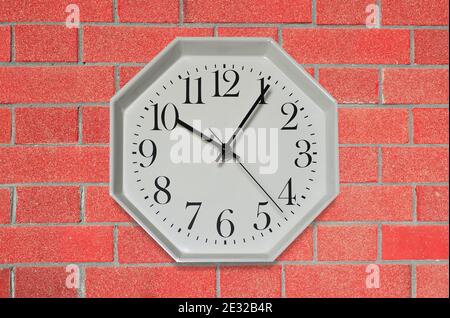 wall clock on a red brick wall Stock Photo