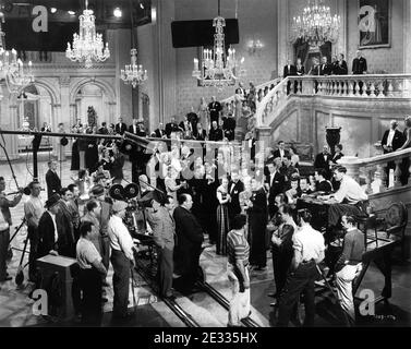 Director ALFRED HITCHCOCK with behind him Cinematographer JOSEPH A. VALENTINE and Movie Crew on set candid directing scenes in huge ballroom set for SABOTEUR 1942 director ALFRED HITCHCOCK original screenplay Peter Viertel Joan Harrison and Dorothy Parker Frank Lloyd Productions / Universal Pictures Stock Photo