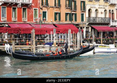 Traditional Venetian gondola, gondolas with tourists on Grand Canal in Venice, Italy Stock Photo