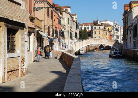 People walk on the Fondamenta Briati next to rio del Carmini canal in the sestiere of Dorsoduro, Venice, Italy Stock Photo