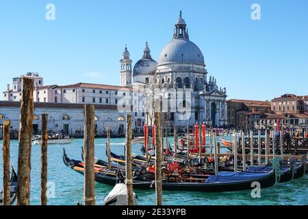 Venetian gondola at Grand Canal, gondolas moored in Venice with Santa Maria della Salute basilica in the background, Italy Stock Photo
