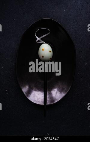 Minimalistic Easter table setting on black concrete background Stock Photo