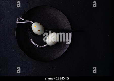 Minimalistic Easter table setting on black concrete background Stock Photo
