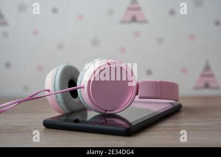 pink headset on mobile phone, selective focus Stock Photo