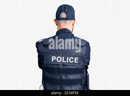 Young handsome man wearing police uniform standing backwards looking away with crossed arms Stock Photo