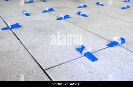 Industrial background. Tile leveling system with plastic clips and wedges, Stock Photo